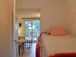 een slaapkamer met een bed en uitzicht op een patio bij Appartement Saint-Aygulf, 1 pièce, 4 personnes - FR-1-226A-89 in Saint-Aygulf