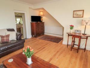 a living room with a couch and a table at Harnham Hall Cottage in Newcastle upon Tyne