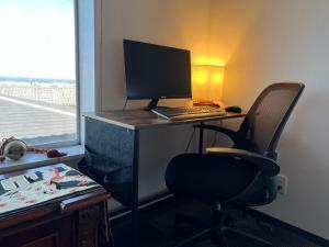 una scrivania con computer e sedia in una stanza di Jonni`s Place a Sakamoto