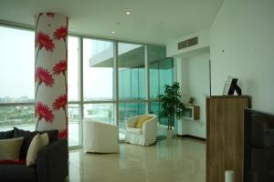 Luxurious Penthouses في دبي: غرفة معيشة مع أريكة وكراسي في مبنى