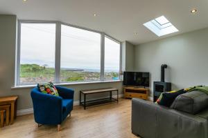 a living room with a couch and a tv and windows at Island View in Amble