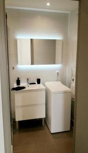 a white bathroom with a sink and a mirror at Appartement 2 pièces LE GORECKI - Résidence DU RIOU DE L'ARGENTIERE à Mandelieu La Napoule, avec piscine, parking et à proximité de tout! in Mandelieu-la-Napoule