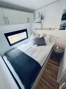 a bed in the middle of a tiny house at Waterview - Schwimmendes Ferienhaus auf dem Wasser mit Blick zur Havel, inkl Motorboot zur Nutzung in Fürstenberg-Havel