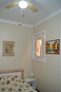 una camera da letto con un letto e un ventilatore a soffitto di Apartments Amber Riga a Riga