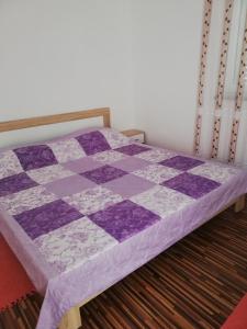 ファジャナにあるApartma Valbandonの客室内のベッドに紫と白の掛け布団