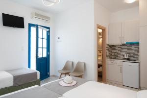 a hotel room with two beds and a kitchen at Theodora Rooms in Kamares