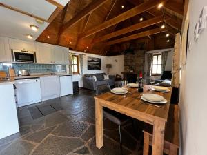 een keuken en een woonkamer met een houten tafel bij Tigh Phadraig at Marys Thatched Cottages in Elgol