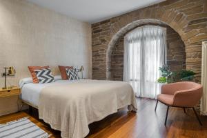 um quarto com uma cama grande e uma parede de tijolos em Always Easy I Ondarreta em San Sebastián
