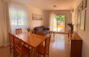uma sala de jantar com uma mesa e um sofá em Kione Villamar em Alcossebre
