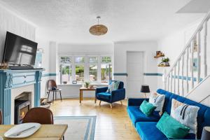 uma sala de estar com um sofá azul e uma lareira em The Pink House em Dartmouth
