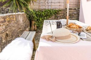 uma mesa com um chapéu de palha e pão em The Pink House em Dartmouth