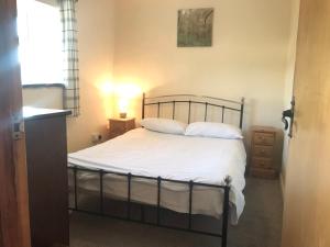 Recently renovated 3-Bed Apartment on Exmoor في مينهيد: غرفة نوم بسرير ذو شراشف ووسائد بيضاء