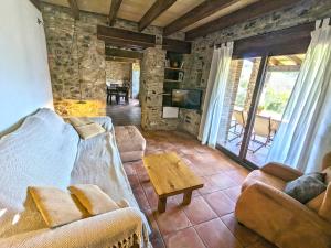 a living room with a couch and a coffee table at Can Nofre - Masia familiar en zona tranquila in Amer +15 photos
