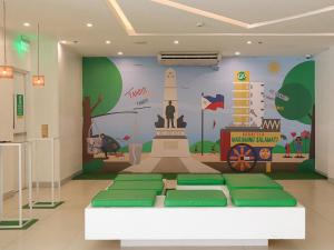 a room with a wall with a mural of a monument at Go Hotels Ermita, Manila in Manila