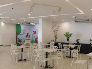 una sala da pranzo con tavoli bianchi e sedie bianche di Go Hotels Ermita, Manila a Manila