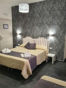 una camera da letto con un grande letto con due asciugamani di Gaisa Naples - Bed and Breakfast a Napoli