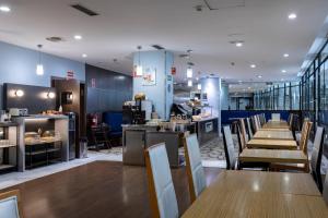 a restaurant with wooden tables and chairs and a counter at Petit Palace Cliper-Gran Vía in Madrid