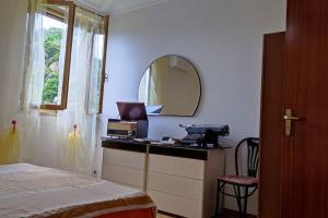 um quarto com uma cama e um toucador com um espelho em Appartamento vista mare em Nicotera Marina