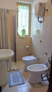 baño con aseo y lavabo y ventana en Appartamento vista mare, en Nicotera Marina