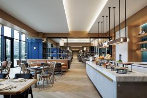 een restaurant met tafels en stoelen en een bar bij Sheraton Kagoshima in Kagoshima