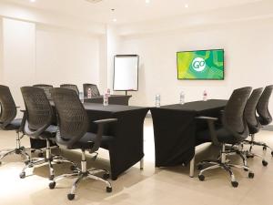 uma sala de conferências com uma mesa preta e cadeiras em Go Hotels North EDSA em Manila