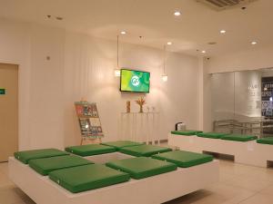 Go Hotels Timog في مانيلا: غرفة انتظار مع مقاعد خضراء في مطعم