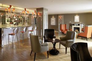 a bar with chairs and a fireplace in a room at The Europe Hotel & Resort in Killarney