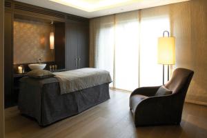 a bedroom with a bed and a chair and a window at The Europe Hotel & Resort in Killarney
