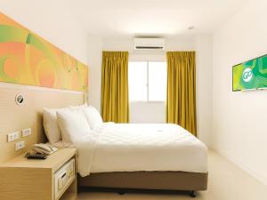a hotel room with a bed and a window at Go Hotels Timog in Manila