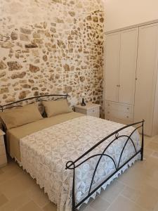 a bedroom with a bed and a stone wall at Arcaroli Borgo Vico "Exclusive" in Vico del Gargano