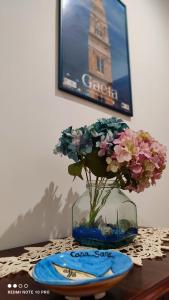 un vaso pieno di fiori seduto su un tavolo di Casa Sara a Gaeta