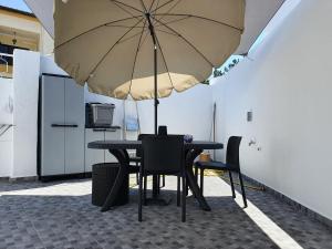 a table and chairs under a large umbrella at Aroeira House in Aroeira