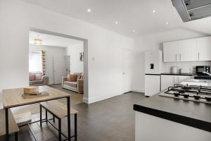 een keuken en een woonkamer met een tafel en een fornuis bij Elegantly 2-Bedroom in Ashington, Sleeps 3 in Ashington