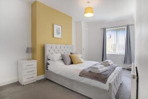 a bedroom with a large bed and a yellow wall at Elegantly 2-Bedroom in Ashington, Sleeps 3 in Ashington