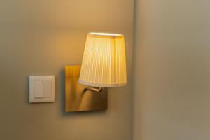 a lamp on a wall next to a lightswitch at Cascais Hotel in Cascais