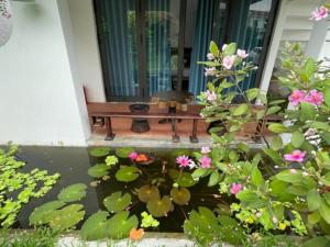 um banco no alpendre de uma casa com flores em La Y Riverview em Hue