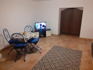 een eetkamer met een tafel en stoelen en een televisie bij Sicilia bedda in Palermo