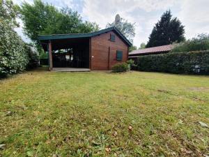 una piccola casa in legno con un ampio cortile di Chalet calme et agréable a Parentis-en-Born