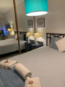 クアルテイラにあるDunas de vilamouraのベッドルーム1室(ベッド2台、タオル、ランプ付)