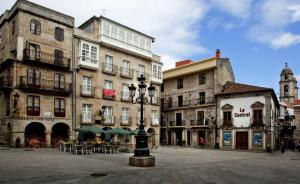 un groupe de bâtiments avec des tables et des chaises dans une cour dans l'établissement Alójate en el corazón de Vigo, à Vigo