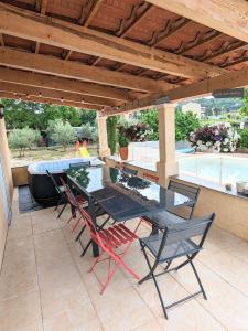 une table et des chaises assises sur une terrasse dans l'établissement Villa en Provence avec piscine et jacuzzi, à Tavernes