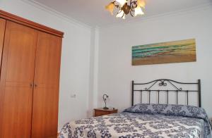 sypialnia z łóżkiem i drewnianą szafką w obiekcie Apartamento Añil w mieście Conil de la Frontera +3 zdjęcia