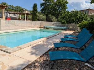 una piscina con due sedie a sdraio blu accanto ad essa di Villa en Provence avec piscine et jacuzzi a Tavernes