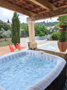 un grand bain à remous dans un jardin avec une pergola dans l'établissement Villa en Provence avec piscine et jacuzzi, à Tavernes