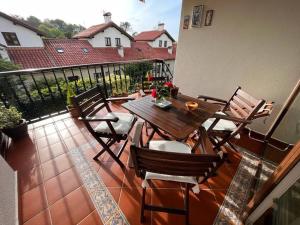 um pátio com uma mesa de madeira e cadeiras numa varanda em Los Girasoles em Comillas