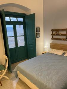 1 dormitorio con cama y puerta verde en Almira Studios and Apartments, en Agia Marina
