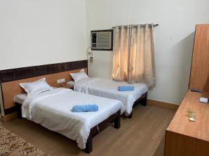 普鲁利耶Hotel Mayur的客房设有两张床和电视。