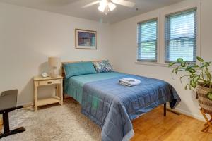 a bedroom with a bed and a table and windows at Walk to Beach Charming Maryland Home with Yard! in Flag Harbor