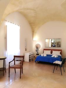 a bedroom with a blue bed and a large window at Dimora Cinzia in Uggiano la Chiesa