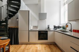 a kitchen with white cabinets and a staircase at Jesticos, A historic beautifully appointed Central pad, Free Parking in Canterbury